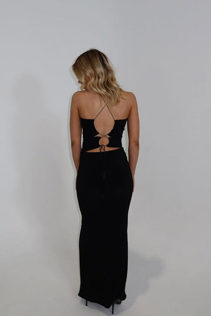 Back view of Decondurate Mia Vita Maxi Dress in black showing halter tie detail and fitted silhouette