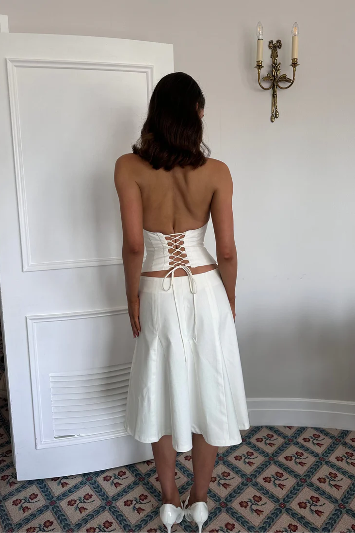 Back view of white set showing fitted structured crop top and smooth tailored skirt silhouette
