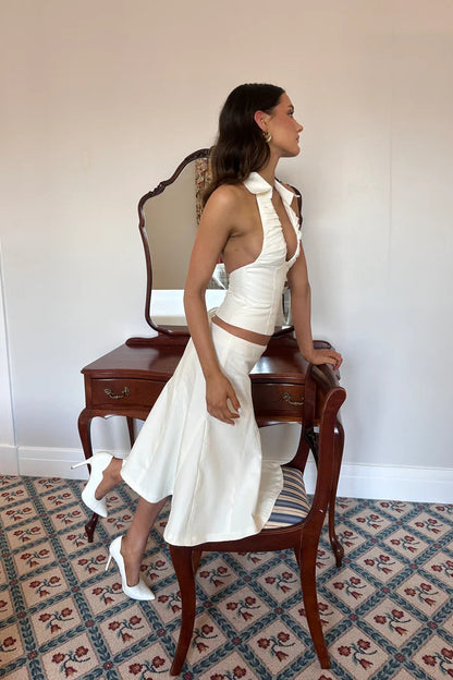 Side profile of white co-ord set showing fitted crop top and structured mini skirt silhouette