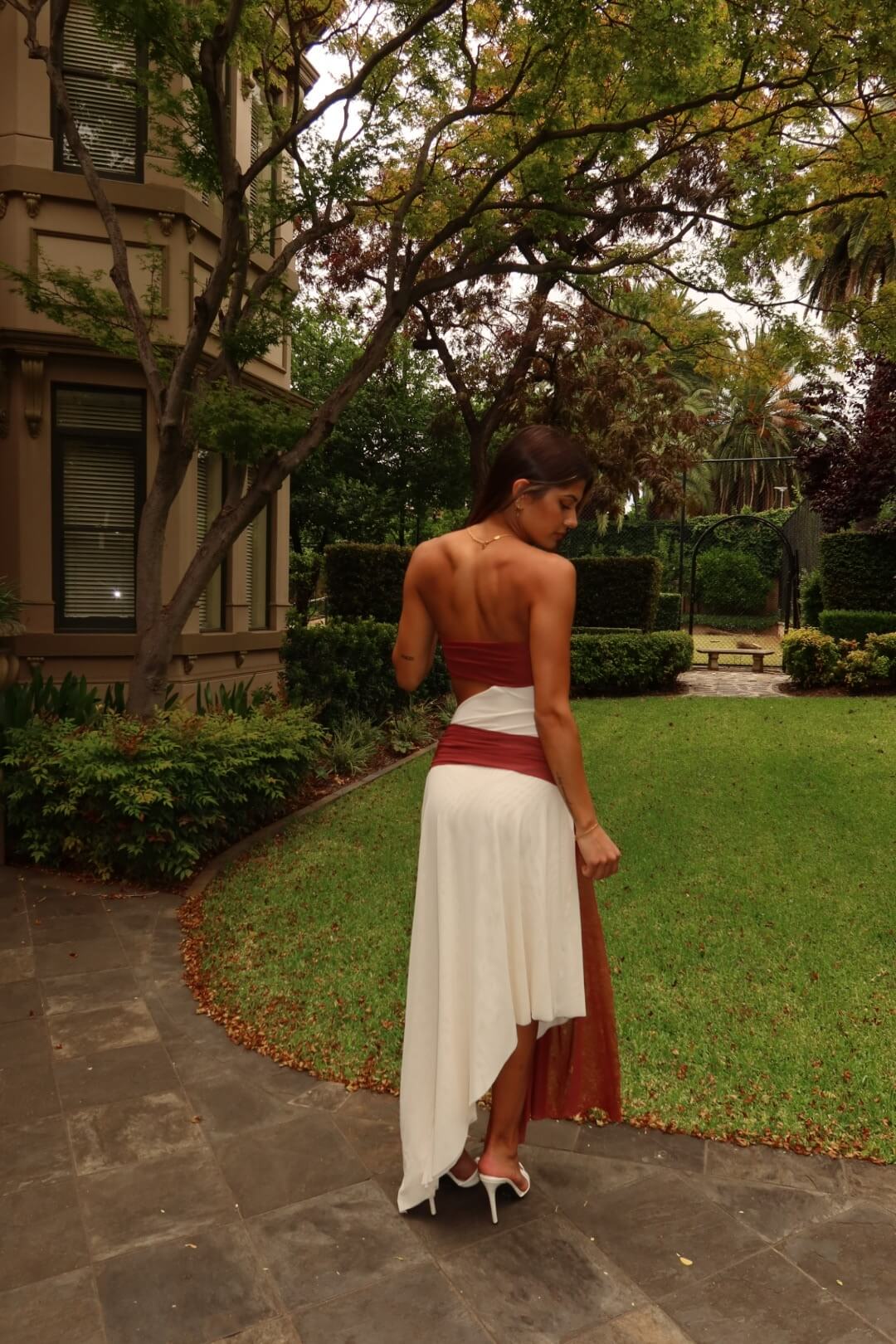 BEC + BRIDGE Ayla Strapless Dress in rust highlighting the elegant back design and flowing maxi silhouette
