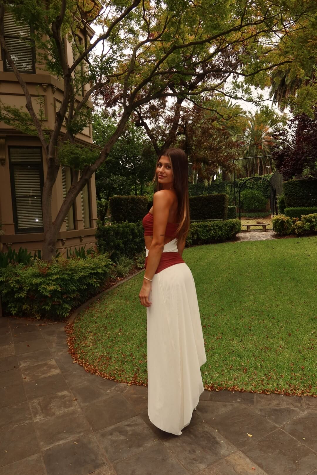 Side view of the BEC + BRIDGE Ayla Strapless Dress in rust showcasing the flattering fitted silhouette