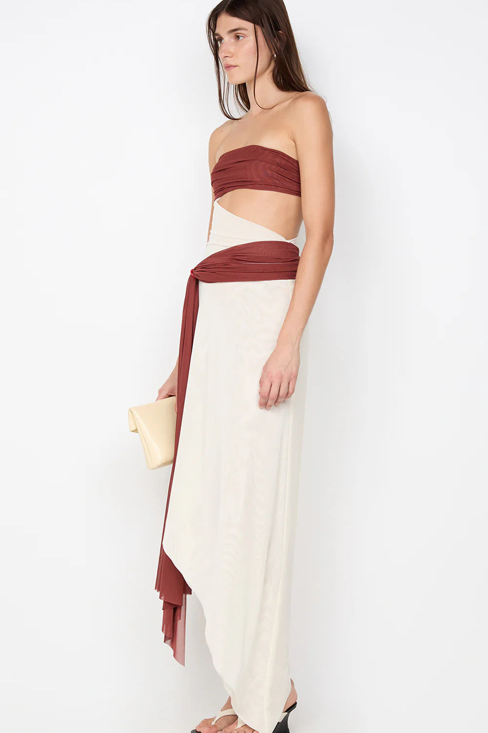 Close detail of waist on rust maxi dress showing sculpted fit and soft draping through the skirt