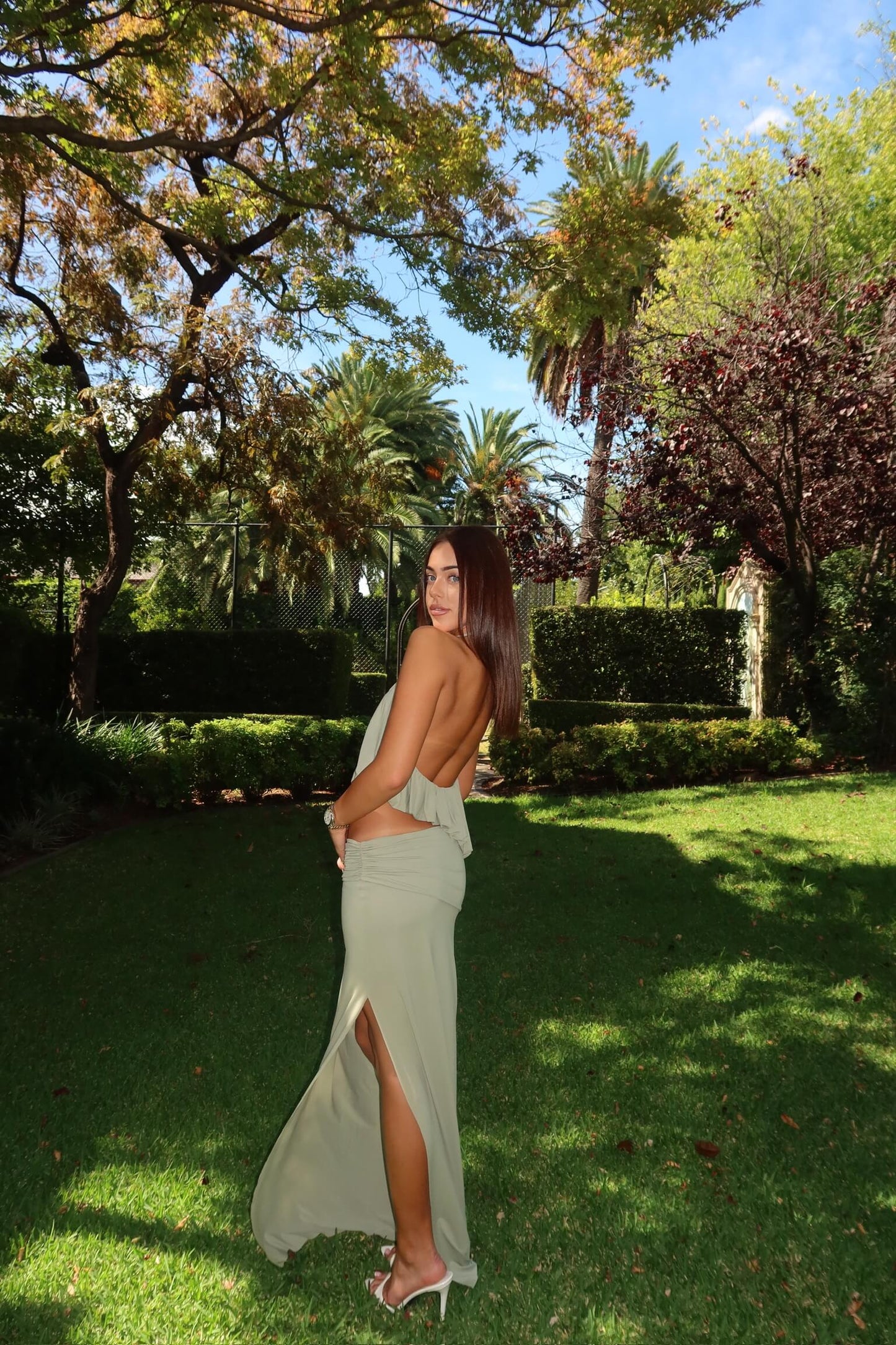 Back view of Bec & Bridge Cadence Racer Maxi Dress in pistachio green showcasing the open back and sleek silhouette, available for dress hire in Adelaide, Australia.