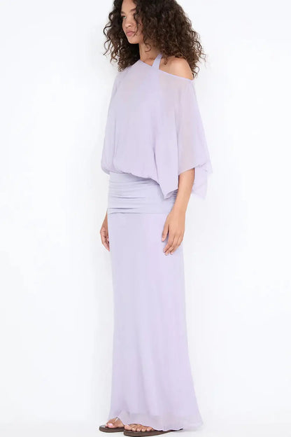 Three quarter front view of Bec & Bridge Delilah Overlay Maxi Dress in purple showcasing the halter neckline, fitted bodice, sheer overlay and flowing floor length silhouette