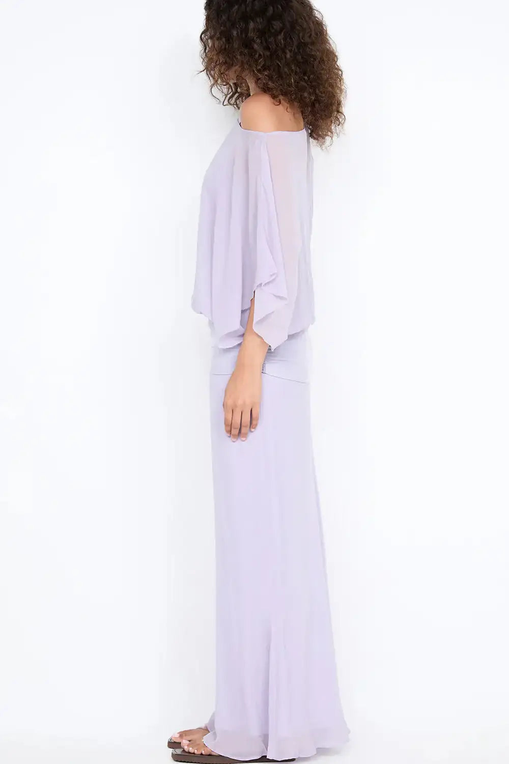 Side view of Bec & Bridge Delilah Overlay Maxi Dress in purple showing body skimming fit, flowing floor length skirt and sheer overlay detail