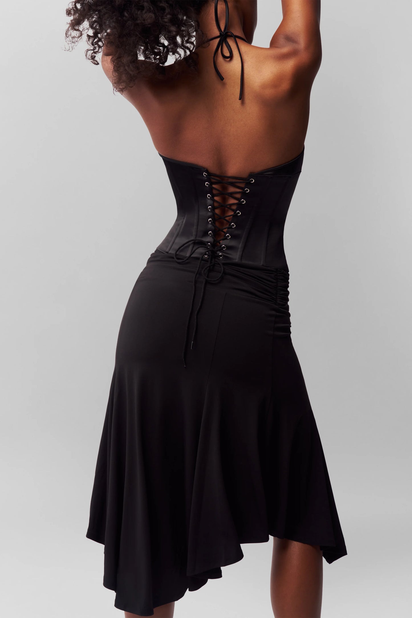 Back view of Danielle Guizio Marini corset set in black showing lattice corset back and fitted mini skirt