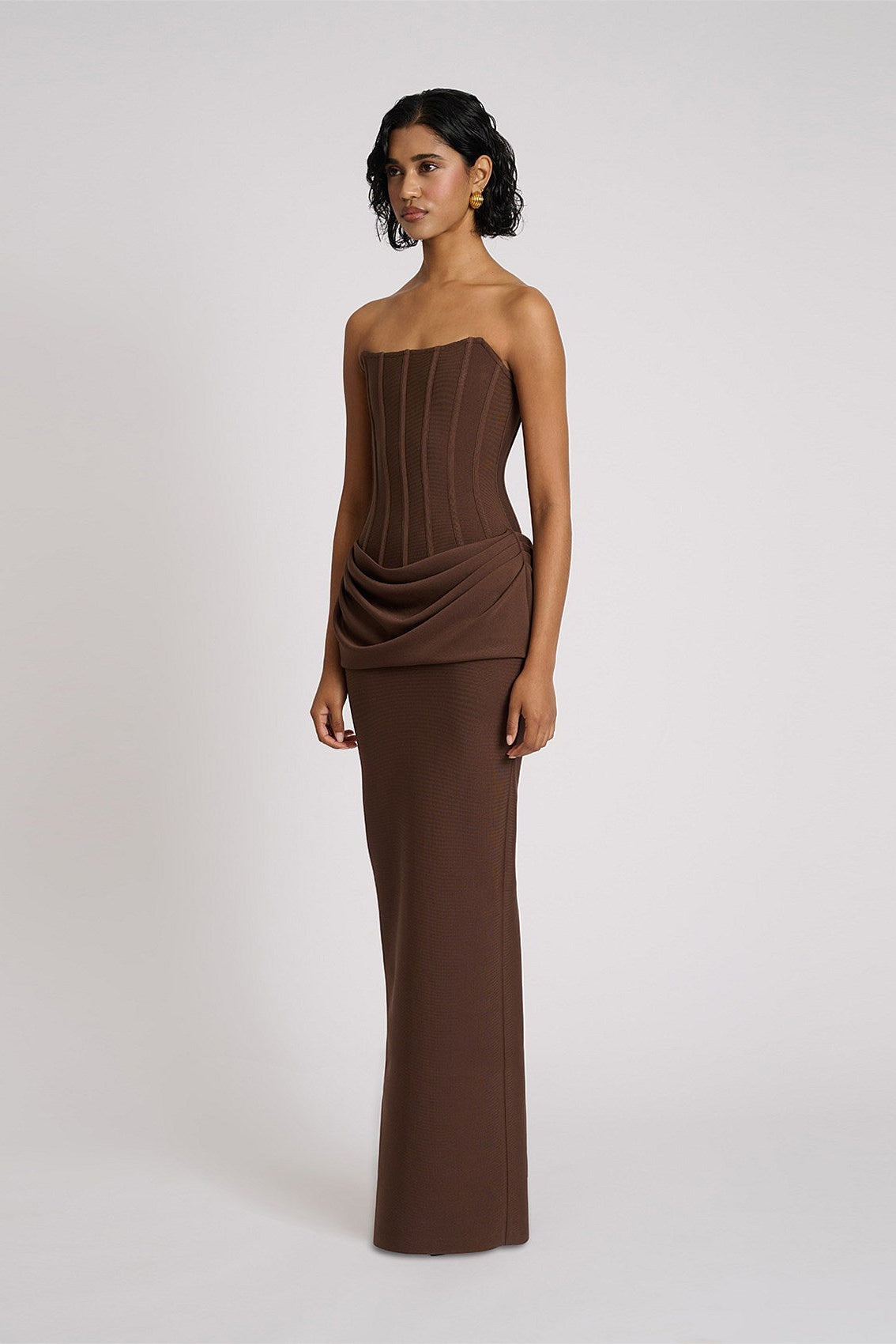 Chocolate brown gown with strapless corset style bodice, fitted waist and flowing maxi skirt for a refined formal silhouette