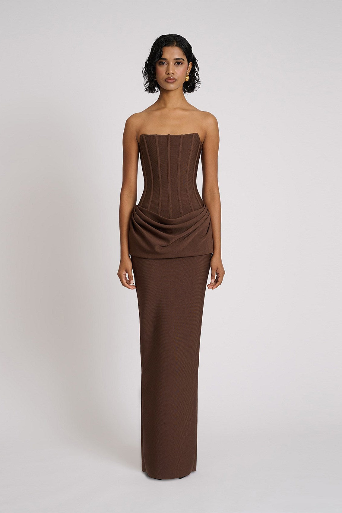 Eliya The Label Hilda Gown in chocolate featuring strapless neckline, structured corset bodice and elegant floor length silhouette with soft draped fabric