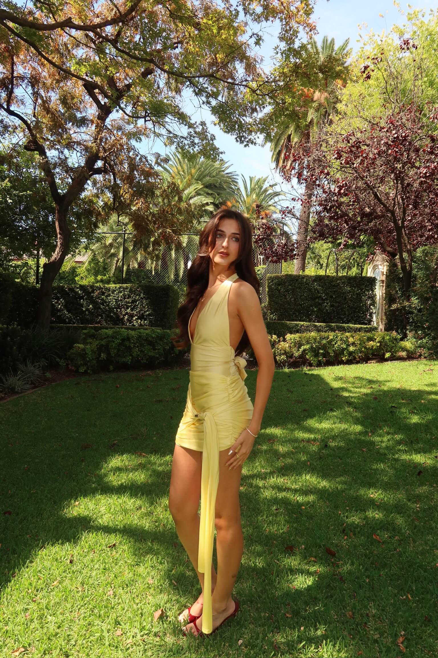 Side view of Imana Swim Kora Set in lemon showing the halter neckline, sculpted fit and mini skirt overlay, available for designer dress hire in Adelaide and Australia.