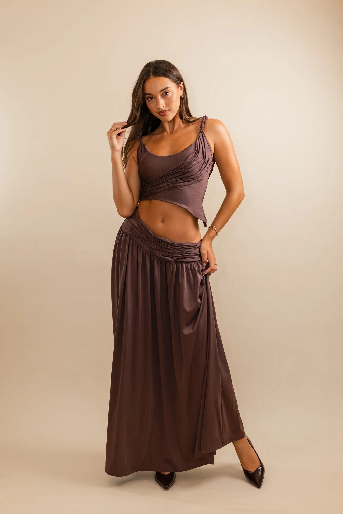 Close detail of sculpted ruched bodice on plum set featuring glossy stretch fabric and body contouring design