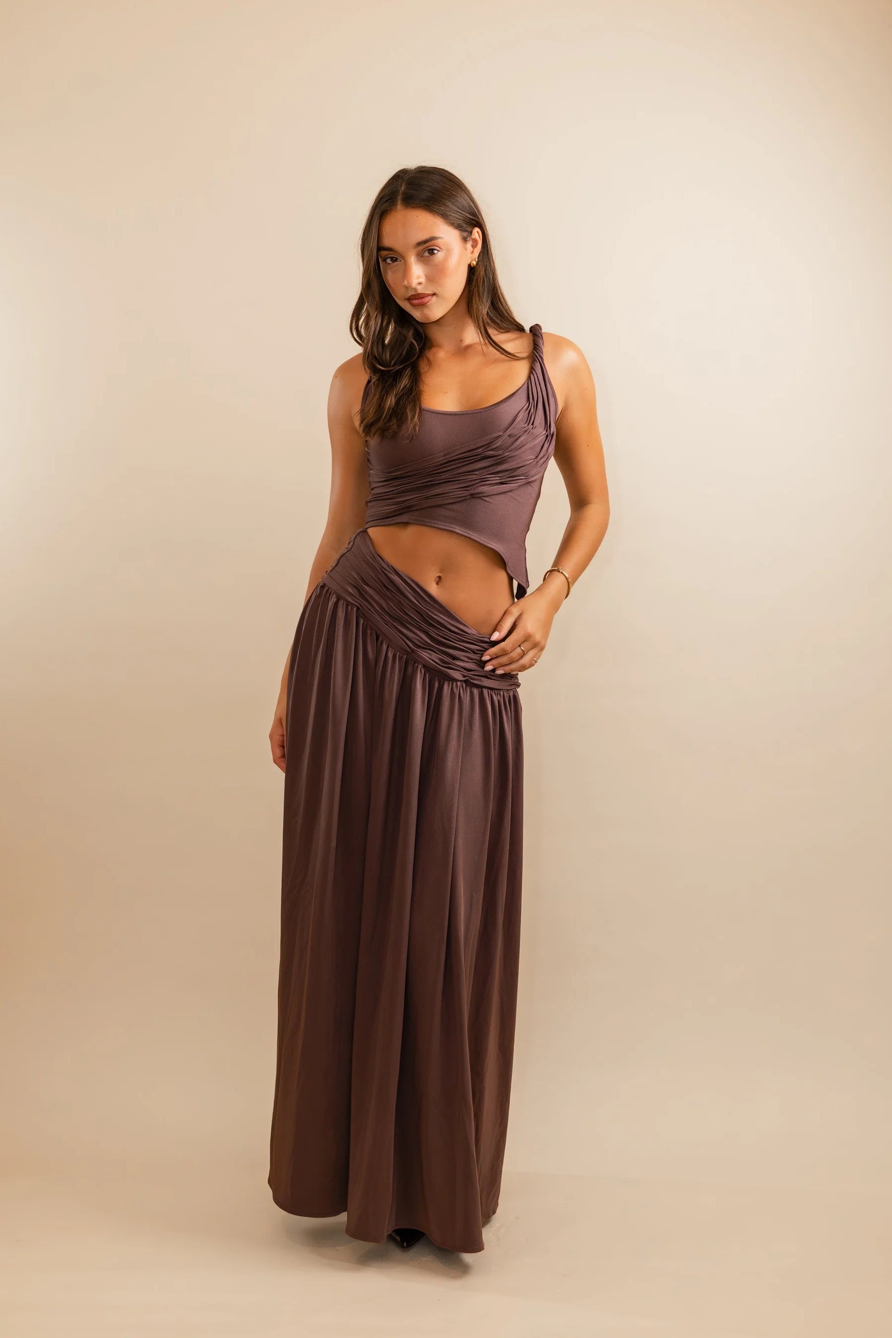 Koster Kulture Calypso Set in plum featuring sculptural draped crop top and matching maxi skirt with fitted stretch silhouette
