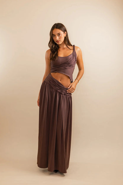Koster Kulture Calypso Set in plum featuring sculptural draped crop top and matching maxi skirt with fitted stretch silhouette