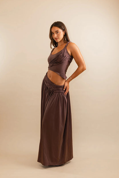 Plum maxi skirt detail showing diagonally scooped waistline and fluid floor length silhouette