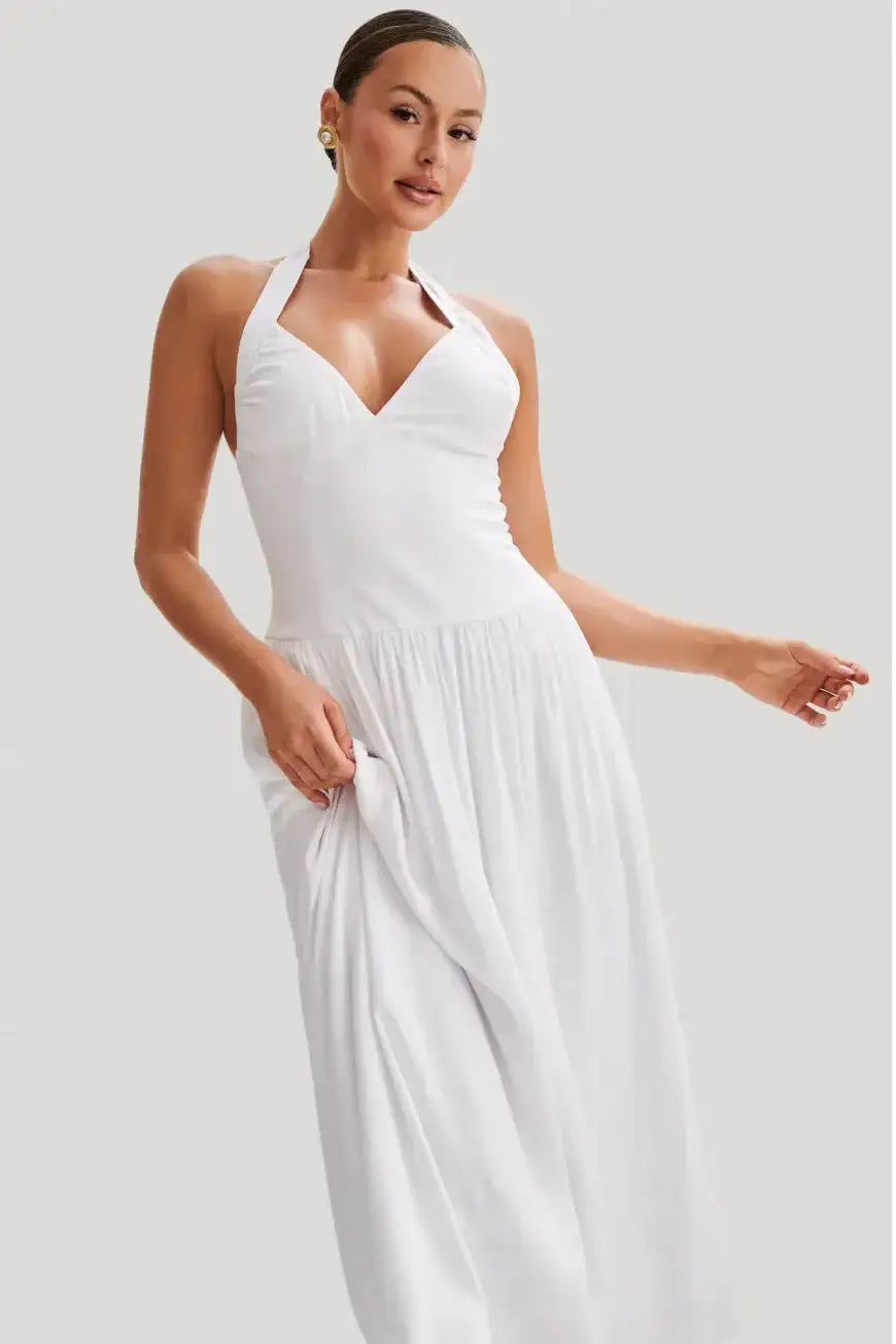 Close detail of cinched waist on white halter midi dress showing sculpted fit and gathered skirt volume