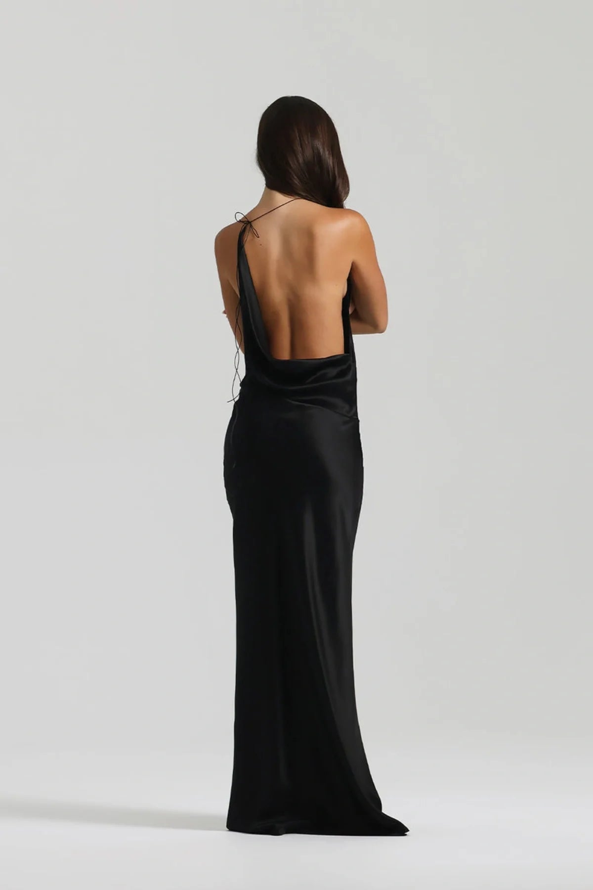 Close detail of waist on black silk gown showing fluid drape and softly structured asymmetrical design line