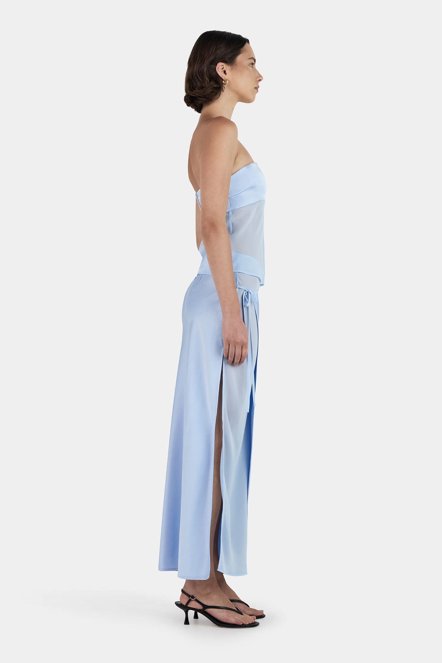 Side profile of baby blue maxi set showing flowing asymmetrical skirt and fitted strapless top silhouette