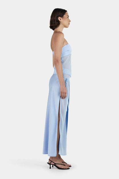 Side profile of baby blue maxi set showing flowing asymmetrical skirt and fitted strapless top silhouette