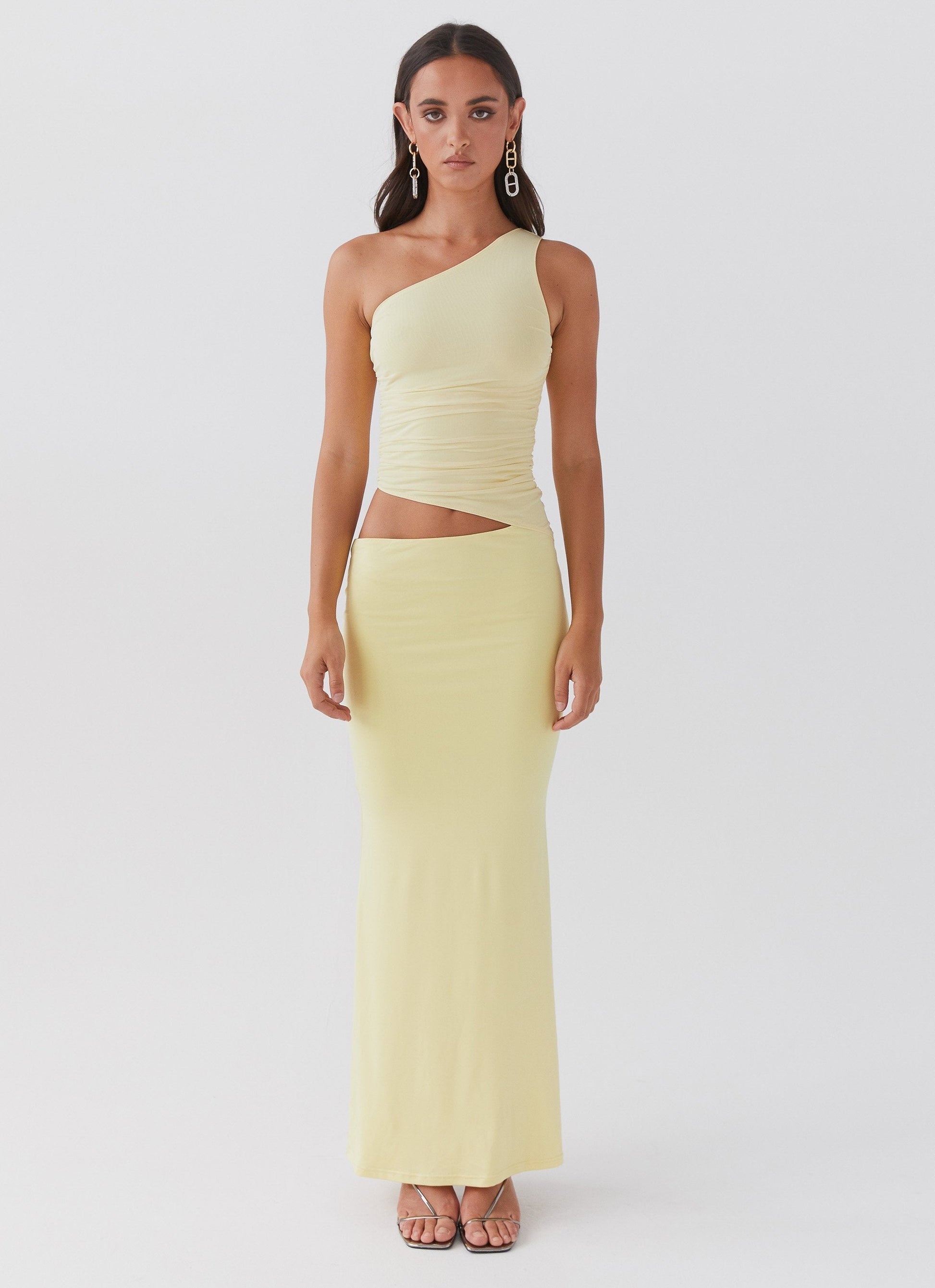 Close up of mesh bodice on yellow maxi dress showing one shoulder neckline and structured ruched detailing