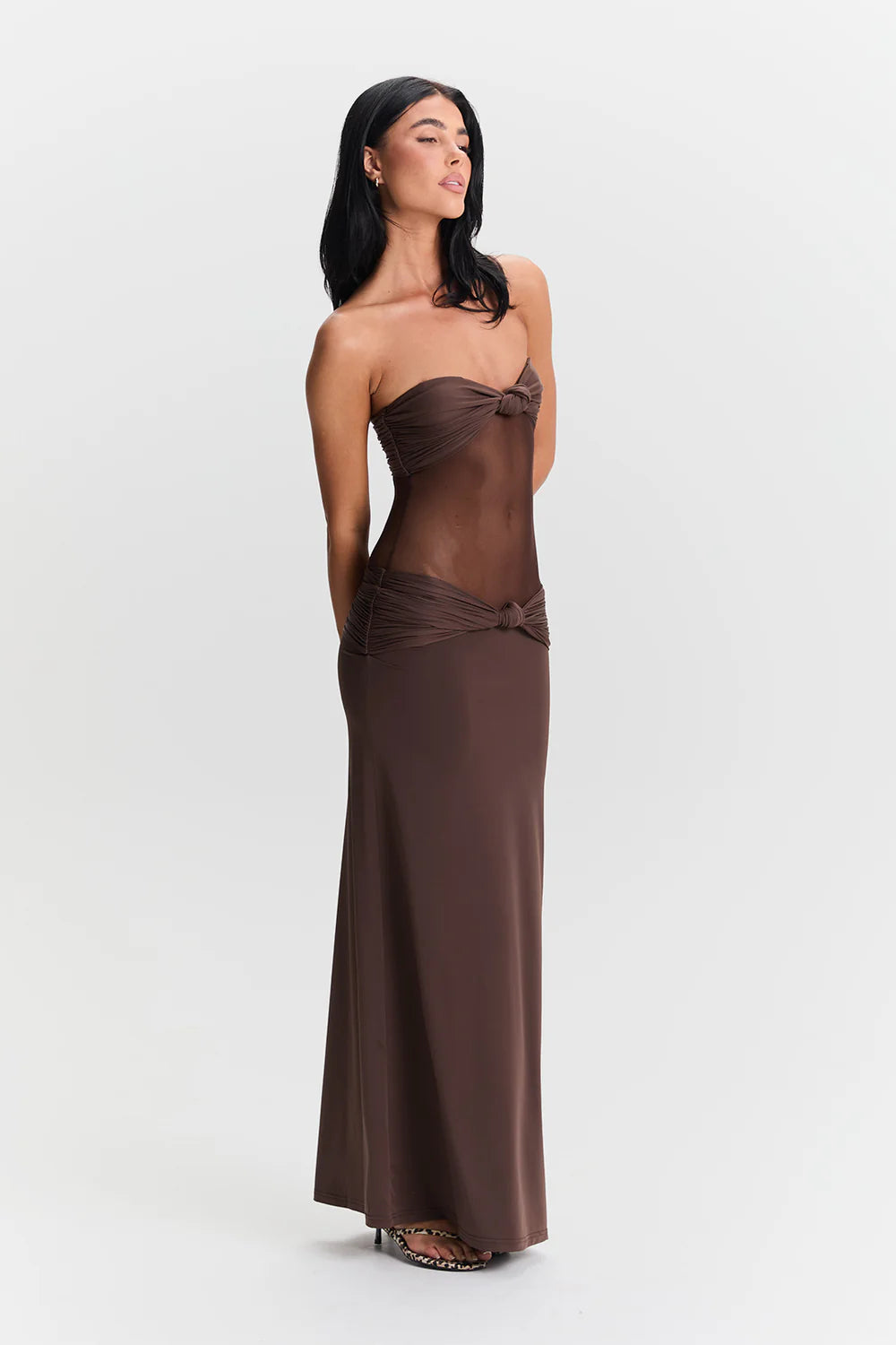 Side profile of brown maxi dress showing body hugging fit and elegant floor length drape