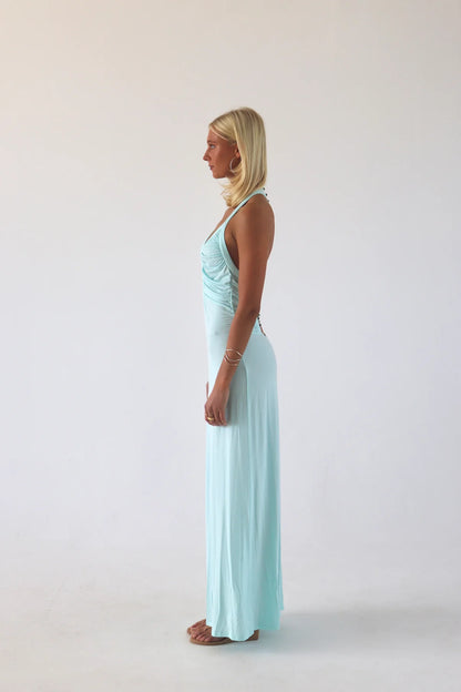 Side profile of aqua maxi dress showing contouring jersey fabric and floor length fitted silhouette