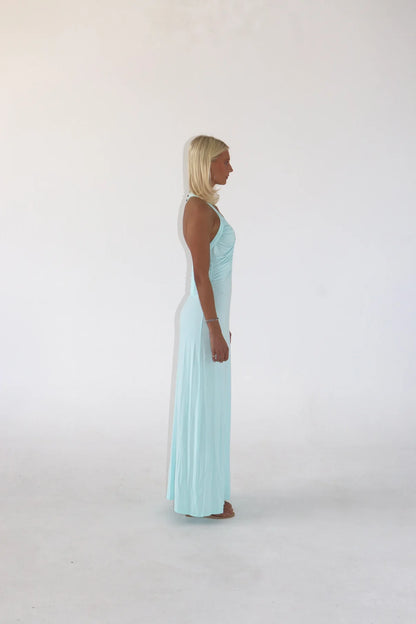 Side profile of aqua maxi dress showing contouring jersey fabric and floor length fitted silhouette