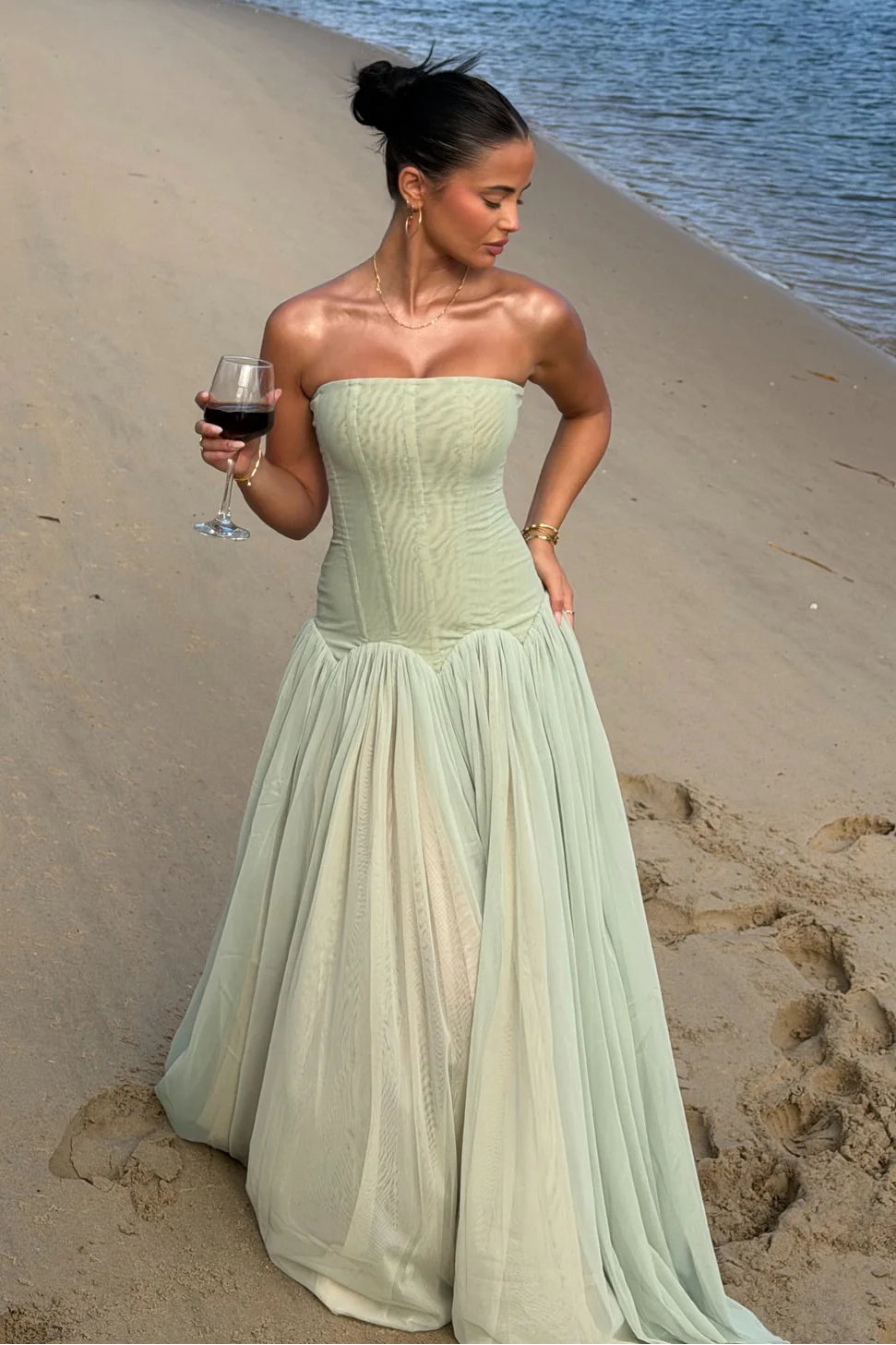 Mint green maxi dress showing drop waist design flowing into a voluminous layered skirt